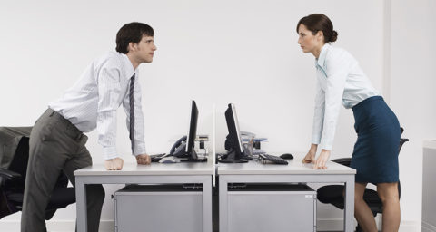 man and woman face off over their desks