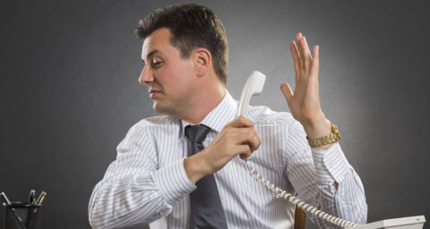 man leaning away from someone yelling into his phone