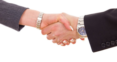 close up of business man and woman shaking hands