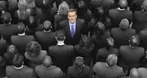 business man looking up in a crowd of business people with backs turned