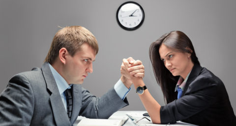 business man and woman arm wrestling